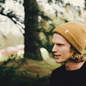 shadow depth of field photography of man in black shirt standing near trees